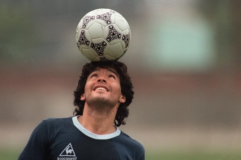 In this file picture taken on May 22, 1986 Argentine football star Diego Maradona, wearing a diamond earring, balances a ball on his head as he walks off the practice field following the national team's practice session in Mexico City. AFP