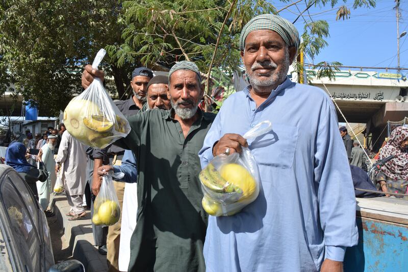 People collect bags of food from the Ramadan relief fruit stall outside Karachi’s jail. All photos: Tariq Ullah for The National