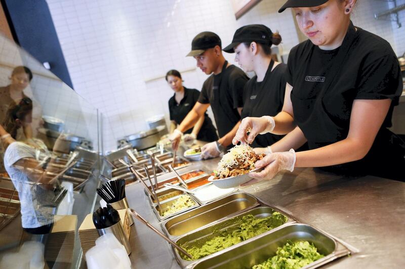 Employees prepare food items including a Chipotle Mexican Grill burrito bowl at the Sunset and Vine store in Hollywood, California, U.S., on Tuesday, July 16, 2013. Photographer: Patrick T. Fallon/Bloomberg