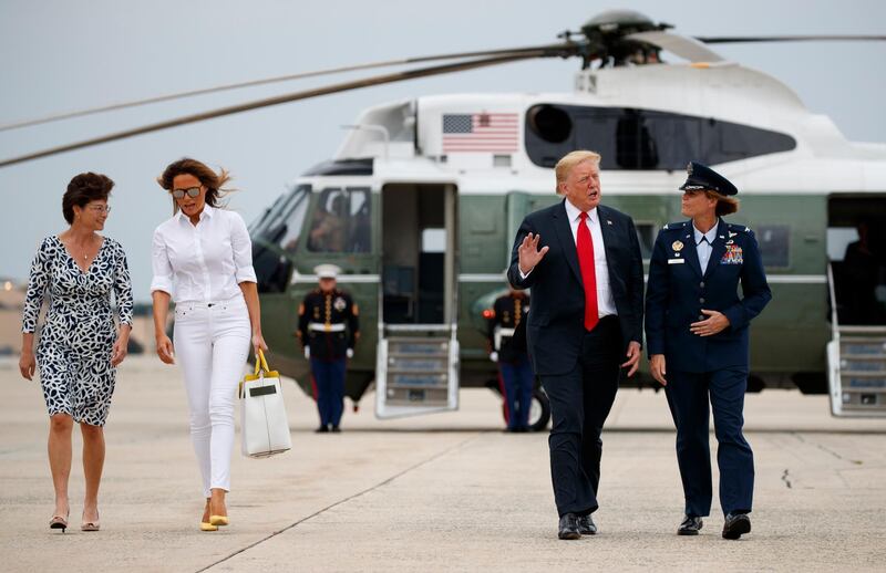 President Donald Trump and first lady Melania Trump walk from Marine One with Col. Rebecca Sonkiss, right, and her wife Kathy Helms, left, to board Air Force One, Friday, July 27, 2018, in Andrews Air Force Base, Md., en route to Morristown Municipal Airport, in Morristown, N.J., and on to Trump National Golf Club in Bedminster, N.J. (AP Photo/Carolyn Kaster)