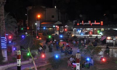 A general view shows an outdoors coffee shop in Hafez al-Assad square, named after the late Syrian president and the father of the current ruler, in Syria's northeastern city of Hasakeh on June 11, 2018 



 For the first time in years, the market of Hasakeh is open past dusk ahead of the Eid al-Fitr feast. For some, the resurgent holiday spirit is a sign that the tensions between the Syrian army and Kurdish forces that ruined the festive occasion in previous years are being worked out.
 / AFP / Ayham al-Mohammad
