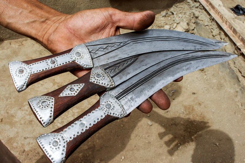 A Yemeni man holds newly-forged daggers.