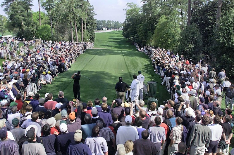 A large gallery of fans line the tee box on the 18th hole as Tiger Woods of the US hits a drive 04 April 2001, during the final practice round for the 2001 Masters Golf Tournament at the Augusta National Golf Club in Augusta, Georgia. The tournament begins 05 April.   AFP PHOTO/Timothy A. CLARY (Photo by TIMOTHY A. CLARY / AFP)