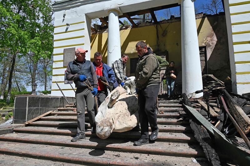 Museum workers carry the sculpture of Ukrainian philosopher Hryhorri Skovoroda from the destroyed building of the Hryhoriy Skovoroda National Literary Memorial Museum  in the village of Skovorodynivka, in Kharkiv Region.  AFP