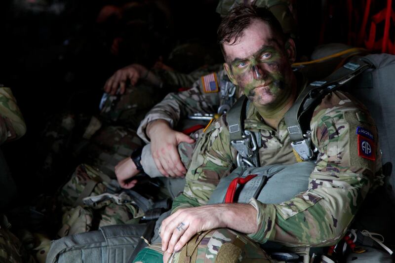 In this Jan. 26, 2020, photo, Sgt Micah Jurekovic waits for takeoff inside a C-130 Hercules transport plane with dozens of other 82nd Airborne Division paratroopers. AP