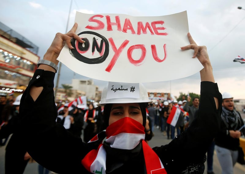 A woman protester holds a sign during ongoing anti-government protests in Basra, Iraq November 29, 2019. REUTERS/Essam al-Sudani