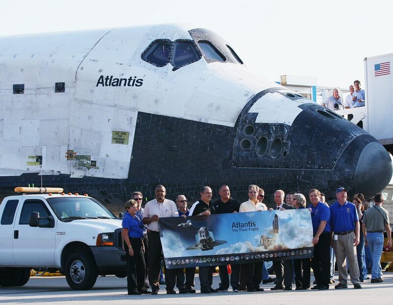CAPE CANAVERAL, FL - JULY 21: NASA workers pose in front of the Space Shuttle Atlantis after it landed at Kennedy Space Center July 21, 2011 in Cape Canaveral, Florida. Atlantis was the final shuttle mission for NASA, ending the 30 years of the shuttle program.   Win McNamee/Getty Images/AFP== FOR NEWSPAPERS, INTERNET, TELCOS & TELEVISION USE ONLY ==
 *** Local Caption ***  464227-01-09.jpg