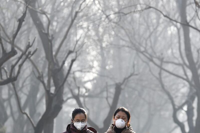 Chinese women wearing masks to protect themselves from air pollution walk through Ritan Park shrouded by dense smog in Beijing. China’s government said on Wednesday that it will stick to its promises to curb carbon emissions after president Donald Trump eased United States rules on fossil fuel use that were meant to control global warming. AP Photo / Andy Wong
