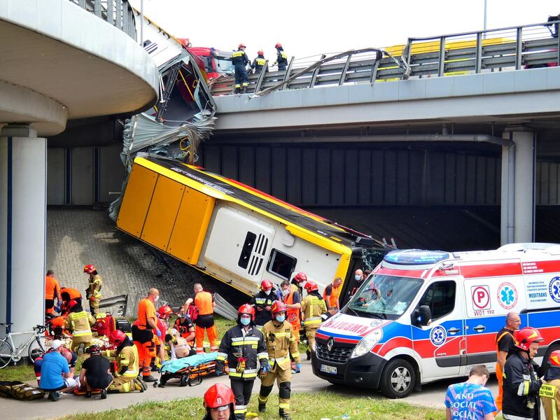 Paramedics treat the injured at the scene of a bus crash in Warsaw, Poland. REUTERS