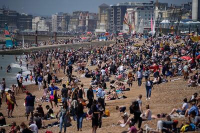 People gather during a hot day on Brighton Beach, in Brighton, on England's south coast, Sunday, May 30, 2021. The bank holiday weekend and relaxation of England's coronavirus restrictions has enabled many people to visit beaches, as warm weather spreads across the UK after what has been a very rainy May. (AP Photo/Matt Dunham)
