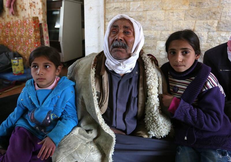 Mehrez Humeidan, 70, who is visually impaired, with granddaughters Ikram, 8, left, and Inaam, 10, in the eastern Lebanese border town of Arsal, after escaping from Syria. Bilal Hussein / AP

