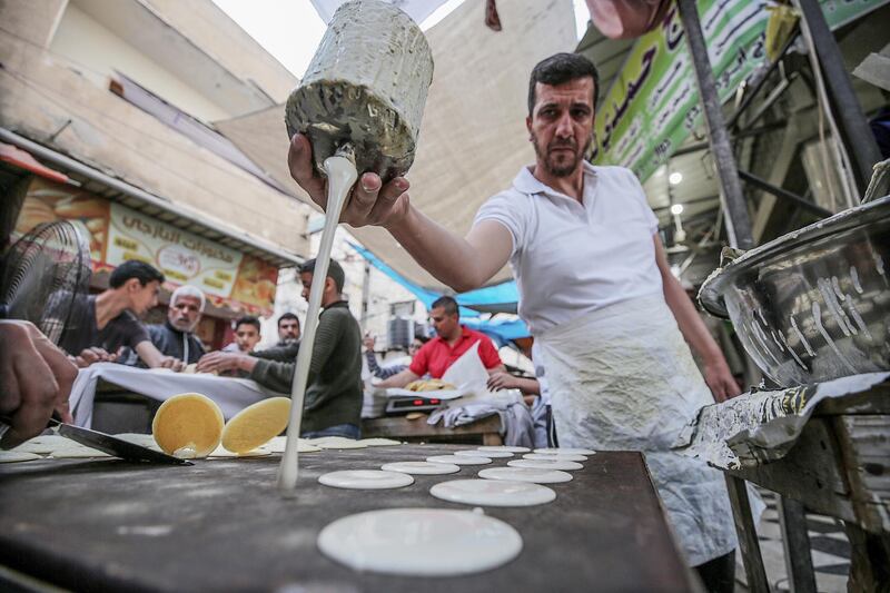 A Palestinian prepares traditional pancakes known as 'Qatayef' in the market of old Gaza City.  EPA