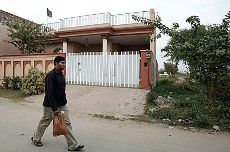 A man walks past the house in the Pakistani city of Sargodha where five American men were reportedly arrested.