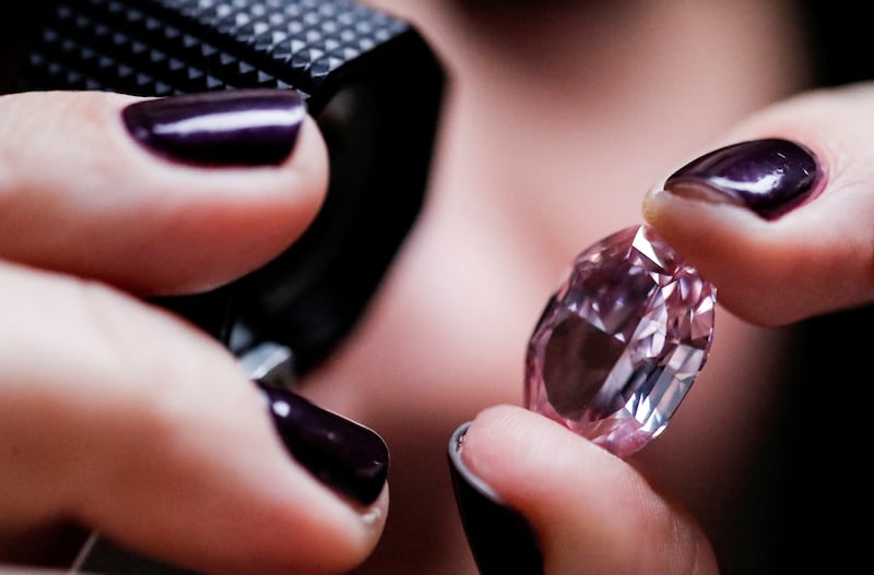 An Alrosa employee holds a 14.83-carat pink diamond during an official presentation in Moscow. Reuters
