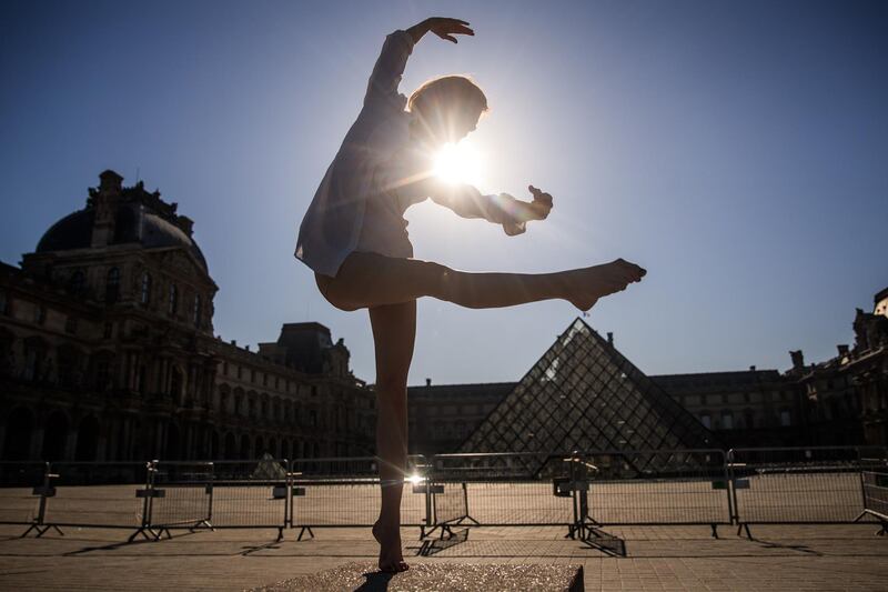 Syrian dancer and choreographer Yara al-Hasbani performs a dance in front of the Lourvre Museum's pyramid in Paris on the 37th day of a strict lockdown in France to stop the spread of COVID-19.  AFP