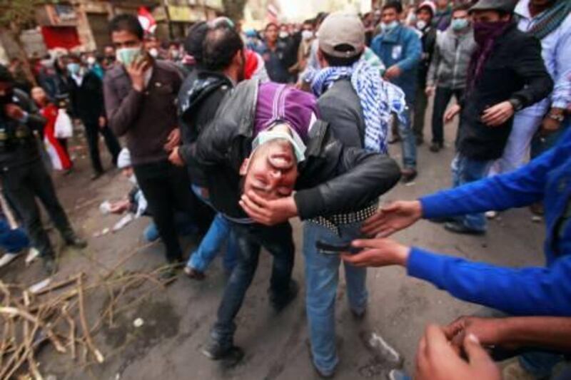 A wounded protester is carried during clashes with security forces near the Interior Ministry in Cairo February 3, 2012. REUTERS/Suhaib Salem (EGYPT - Tags: POLITICS CIVIL UNREST) *** Local Caption ***  SJS15_EGYPT-PROTEST_0203_11.JPG