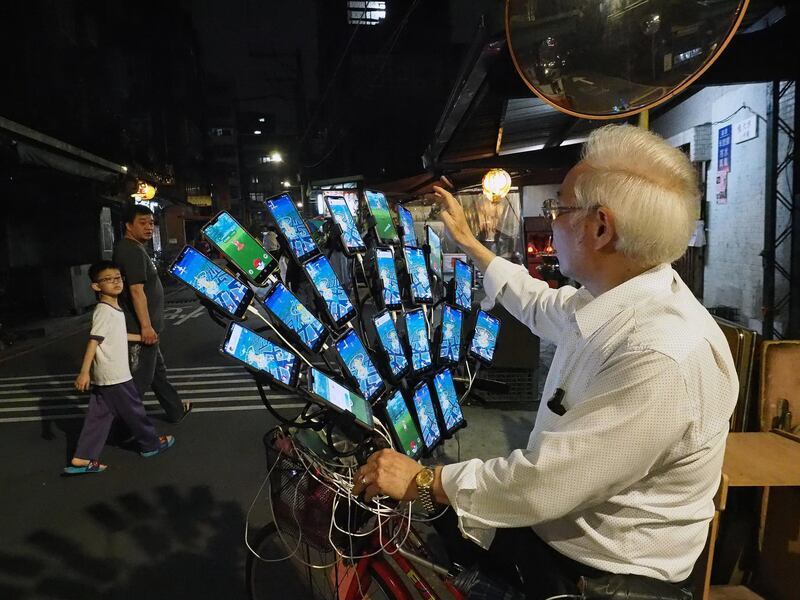 Chen San-yuan, a 70-year-old Feng Shui master, uses 22 cellphones mounted on his bike to catch Pokemon in New Taipei City, Taiwan. EPA