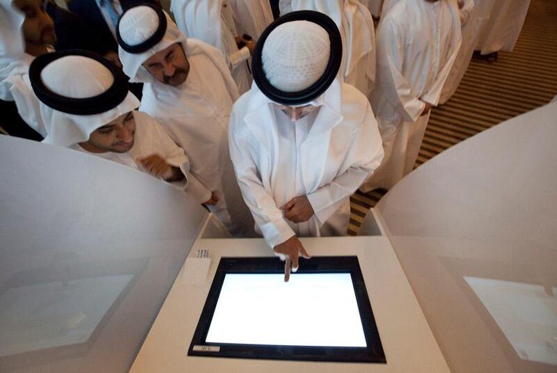 UAE - Dubai - Aug 10 - 2011: Emirati men check the new voting machine for the Federal National Council Elections day, at Raffles Hotel. ( Jaime Puebla - The National Newspaper )