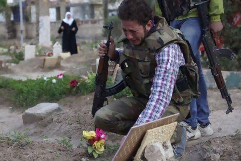 A Free Syrian Army fighter mourns at the grave of his father who was killed by what activists say was shelling by forces loyal to Syria's President Bashar Al Assad.