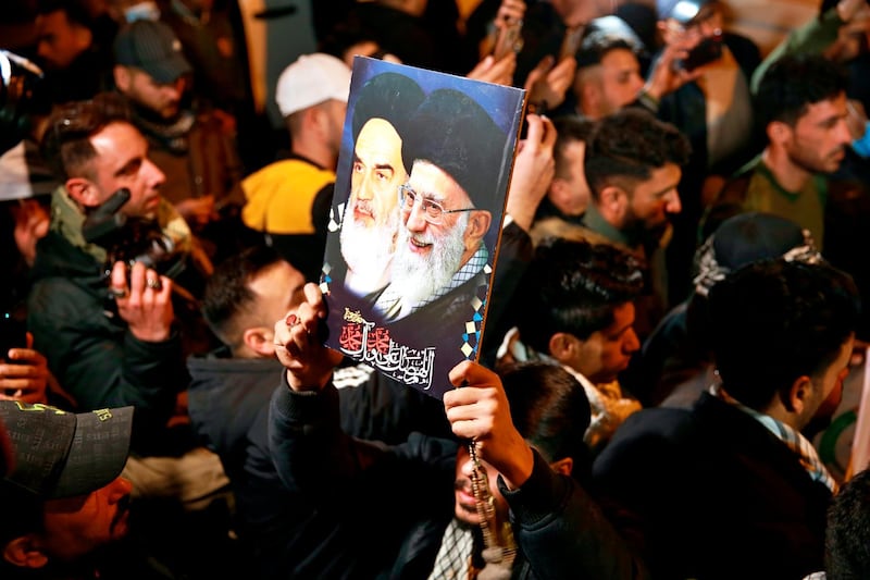 Members of the Popular Mobilization Forces (PMF) and their supporters chant slogans against the United States at Baghdad's international airport, for the anniversary of the killing of Abu Mahdi al-Muhandis, deputy commander of the PMF, and Gen. Qassem Soleimani, head of Iran's Quds Force in a US airstrike. AP Photo