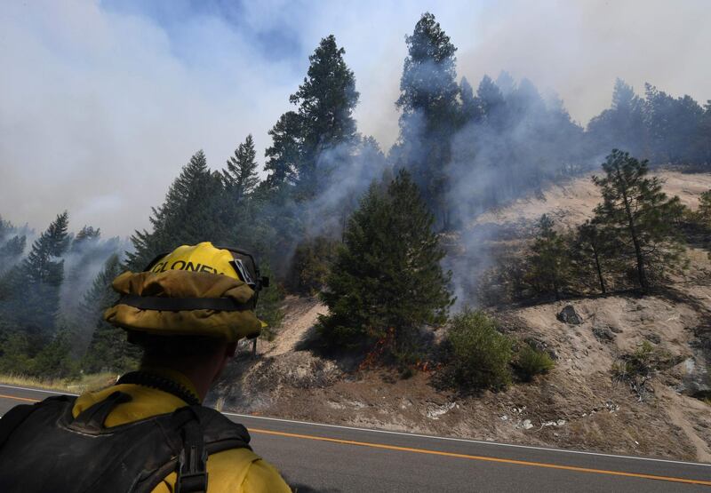 A firefighter keeps watch at a containment line as they battle flames from the Carr fire as it spreads towards the town of Douglas City near Redding, California.  AFP PHOTO / Mark RALSTON