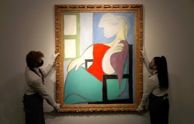 Employees pose for a photograph with "Femme Assise Pres d'Uune Fenetre (Marie-Therese)" by Pablo Picasso at Christie's gallery prior to the New York spring season of evening sales, in London, Britain, April 22, 2021. REUTERS/Peter Nicholls   NO RESALES. NO ARCHIVES.