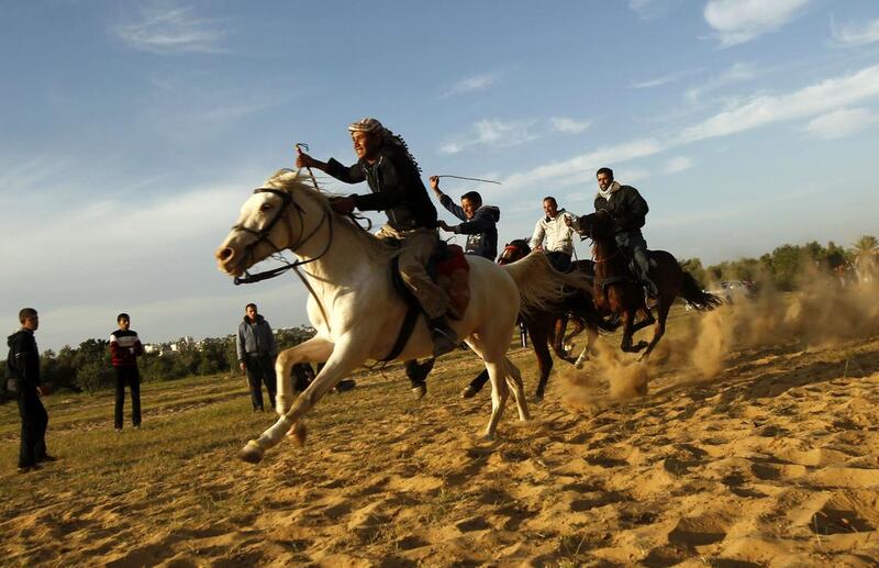 Palestinian men ride their horses as they compete in a local race in the southern Gaza Strip town of Khan Yunis. Said Khatib / AFP  