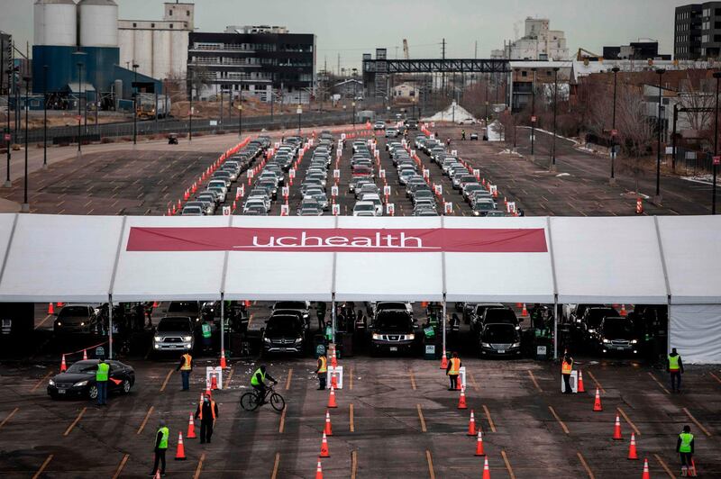 People arrive for a Covid-19 vaccination at a drive-through set up at Coors Field baseball stadium in Denver, Colorado.  UCHealth, the organiser and Colorado's largest healthcare provider, aims to vaccinate 10,000 people over the weekend. AFP