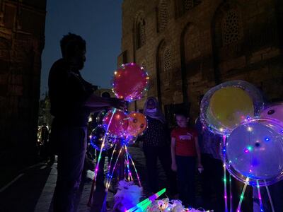 This May 2, 2021 photo shows a balloon seller at the historical El Moaz Street in Cairo‚Äôs Islamic quarter. Hamza Hendawi/ The National