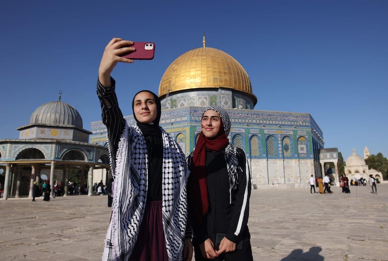 Palestinian women take a selfie in front of the Dome of the Rock mosque. AFP