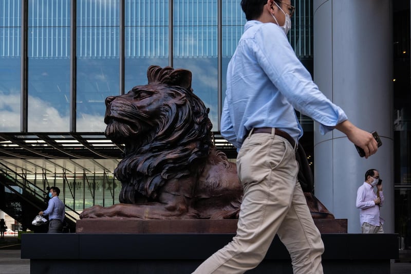 Pedestrians past a statue of a lion in front of the HSBC Holdings Plc headquarters building in Hong Kong. Bloomberg