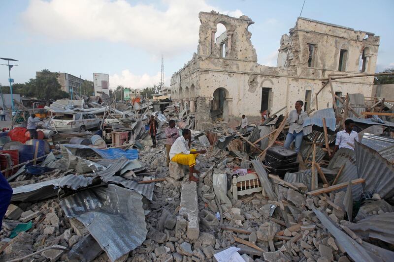 Locals walk through destroyed building following a twin car bomb attack in the capital Mogadishu, Somalia. Farah Abdi Warsameh / AP Photo