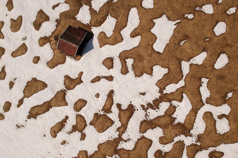 An aerial picture taken with a drone shows a barn between patches of melting snow on a meadow near Gerold, Germany. EPA
