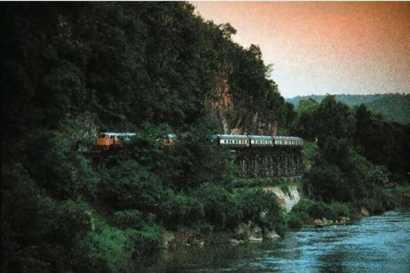 The Eastern and Oriental Express crosses the Kanchanburi Bridge in Thailand.