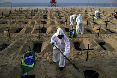 Activists dig graves on the beach to symbolise the dead from Covid-19 during a demonstration in Rio de Janeiro, Brazil. Reuters