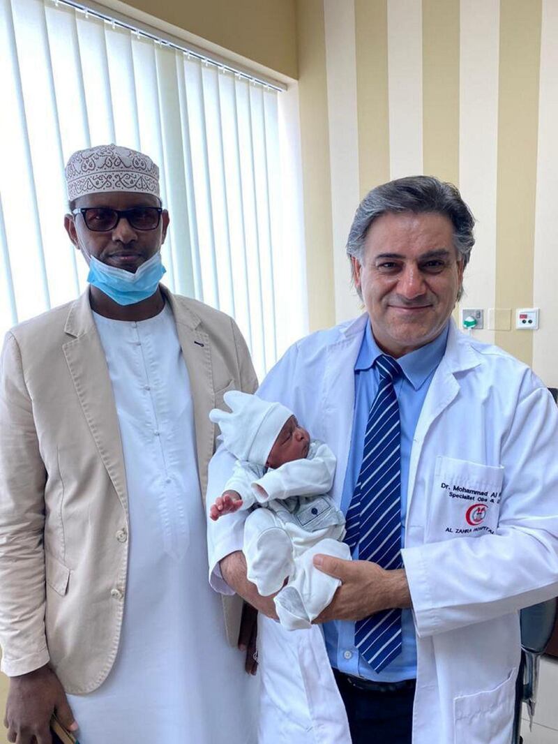 Doctor Muhammad al Hassoun, specialist in obstetrics and gynecology and infertility, holding baby Maher born to Somalian couple who finally had a boy after 20 years of trying to conceive as Noor Eldeen, father of the baby looks on.
