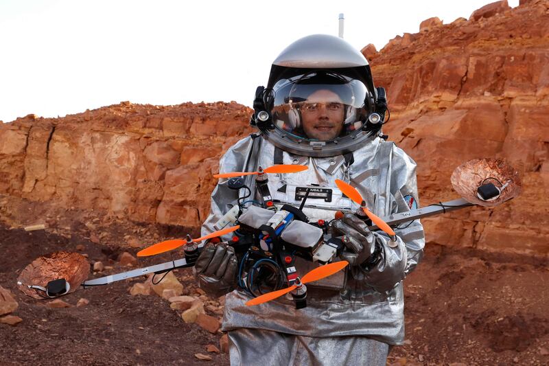Handling a drone while wearing a spacesuit requires dexterity. AFP