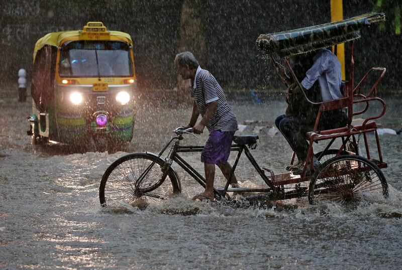 A man pedals his cycle rickshaw during monsoon rains in New Delhi.  Cathal McNaughton / Reuters