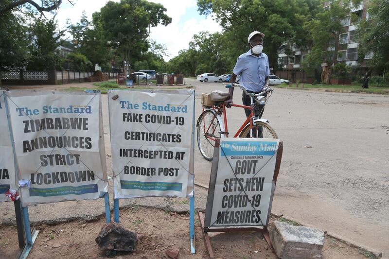 A man walks past posters with newspaper headlines in Harare, Zimbabwe. EPA