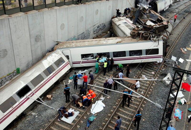 Rescuers tend to victims next to derailed cars at the site of a train accident near the city of Santiago de Compostela on July 24, 2013. Between 45 and 50 people died when a train derailed in Galicia in northwestern Spain today, the president of the regional government of Galicia said. The train which carried 238 passengers originated in Madrid and was bound for the northwestern town of Ferrol.  AFP PHOTO / OSCAR CORRAL
 *** Local Caption ***  611039-01-08.jpg