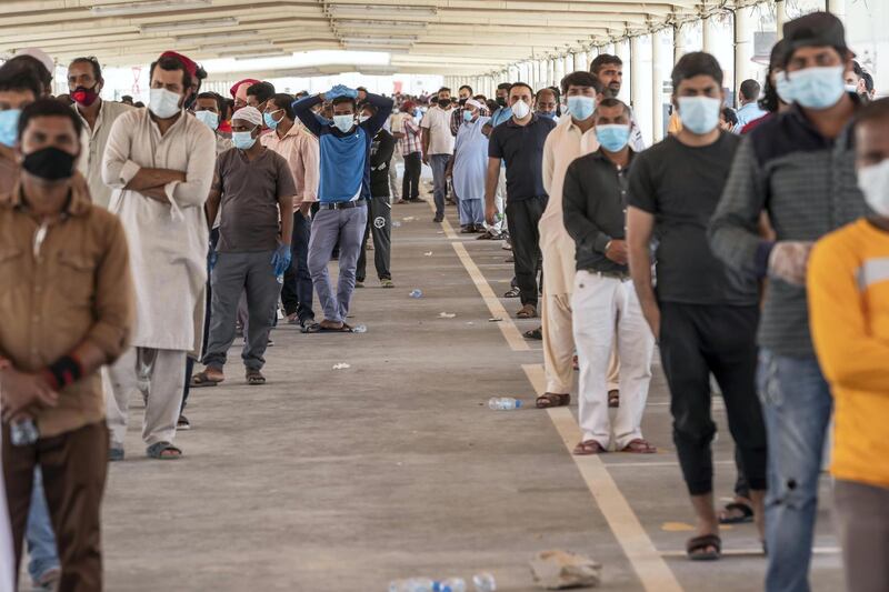 ABU DHABI, UNITED ARAB EMIRATES. 16 APRIL 2020. COVID-19 Testing station in Al Mussafah. Men wait in line for their pre-check ahead of being tested. (Photo: Antonie Robertson/The National) Journalist: Haneen Dajani. Section: National.