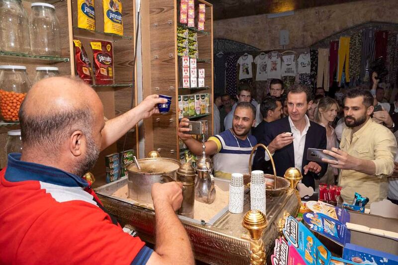 The president drinks coffee at Aleppo's historic souk. AFP