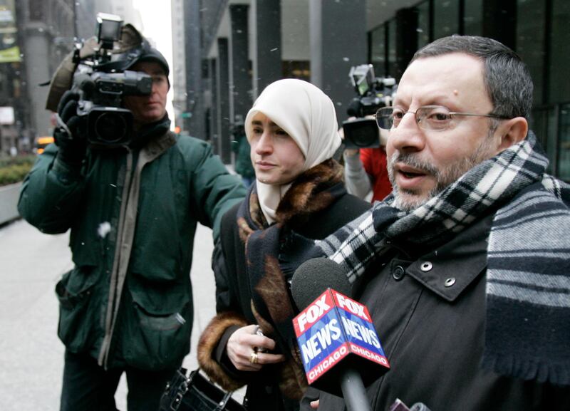 FILE - In this Feb. 1, 2007 file photo, Abdelhaleem Ashqar is surrounded by cameramen as he leaves federal court with his wife, in Chicago. Ashquar who says he fears torture at the hands of Israeli authorities,  is back in the U.S. after a judge's order forced immigration authorities to reverse his deportation and bring him back from Israel before he ever got off the plane.  According to court papers and interviews, U.S. authorities arrested and deported Ashqar Tuesday, June 4, 2019  after misleading him about his need to report to an immigration office to process paperwork.  (AP Photo/Charles Rex Arbogast)