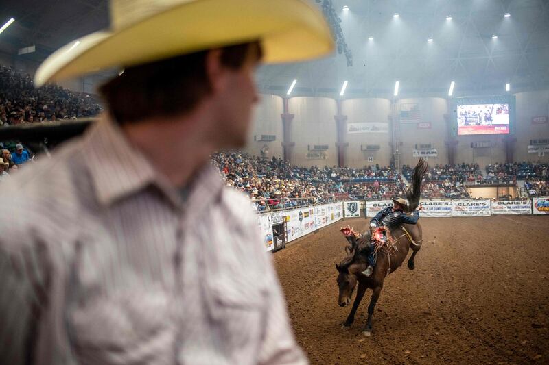A spectator looks on as a horse and rider perform at the San Angelo Stock Show and Rodeo in San Angelo, Texas, US. This was the first rodeo with no restrictions in San Angelo since the beginning of the coronavirus pandemic. AFP