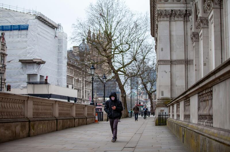 A pedestrian, wearing a protective face mask, while walking through the Westminster district of London, U.K.. U.K. Prime Minister Boris Johnson's government is considering tougher action to fight the spread of the coronavirus in London but has denied it is planning to confine residents to their homes or seal off the city. Bloomberg