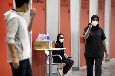 A nurse gives a thumbs up at Manama's repurposed convention centre, in which 6,000 people are participating in a large-scale trial of a Chinese-sponsored vaccine for the Covid-19 coronavirus, on August 27, 2020 in the Bahraini capital. - Chinese drug giant Sinopharm began testing the inactivated COVID-19 jab in Bahrain earlier this month after starting a similar trial on 15,000 subjects in the nearby United Arab Emirates in July. The current phase of the study, in which the vaccine's efficacy and safety is tested in a large cross-section of the population, is due to last until July 2021. (Photo by Mazen Mahdi / AFP)
