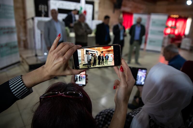 A woman films the rally in Sarafand.