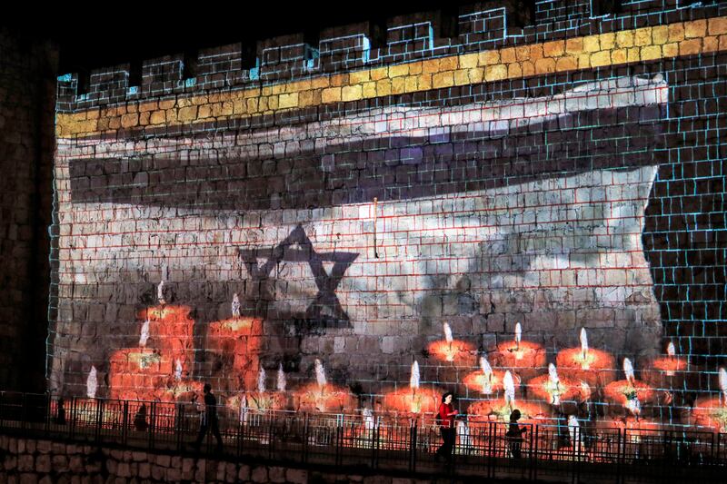 A projection of an Israeli flag on the old city walls in Jerusalem on May 2, 2021, as Israel declared a national day of mourning for victims of a stampede during the Lag Bomer holiday at Mount Meron. The deadly crush at Mount Meron in northern Israel is described as one of the worst peacetime disasters since the nation's founding in 1948. AFP