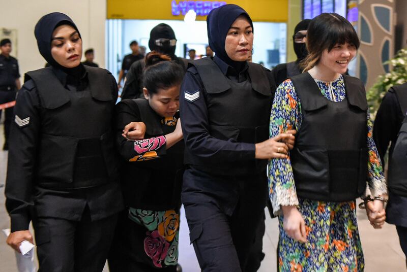 Vietnamese defendant Doan Thi Huong (R) and Indonesian defendant Siti Aishah (2nd, L) are escorted by police personnel at the low-cost carrier Kuala Lumpur International Airport 2 (KLIA2) in Sepang during a visit to the scene of the murder as part of the Shah Alam High Court trial process on October 24, 2017, for their alleged role in the assassination of Kim Jong-Nam.  
Indonesian Siti Aisyah, 25, and Huong, 28, have been charged with the murder of Kim Jong-Nam, the estranged half-brother of North Korean leader Kim Jong-Un, at Kuala Lumpur International Airport 2 (KLIA2) in February. / AFP PHOTO / MOHD RASFAN