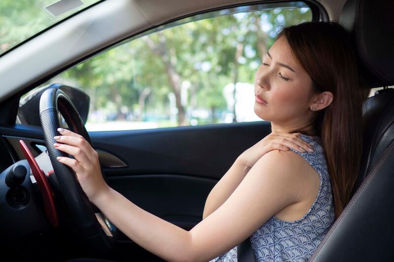 Young woman having pain her shoulder after driving. Getty Images